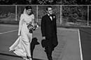 bride and groom walking in the tennis court- Waikanae Wedding