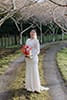 bride lovingly standing in the middle of the road with her florals- Waikanae Wedding