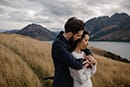 bride and groom hugging lovingly in the middle of the mountains- New Zealand Elopements