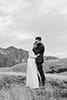 bride and groom lovingly standing in the middle of the mountains- New Zealand Elopements