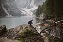 bride and groom helping each other climb the mountain- New Zealand Elopements