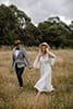 bride and groom happily walking in the middle of the mountains as the cold breeze pass by them- New Zealand Elopements