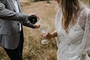 bride and groom pouring wine in the middle of the mountains- New Zealand Elopements