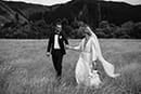 bride and groom lovingly holding each other as they walk in the middle of the grassy land- New Zealand Elopements